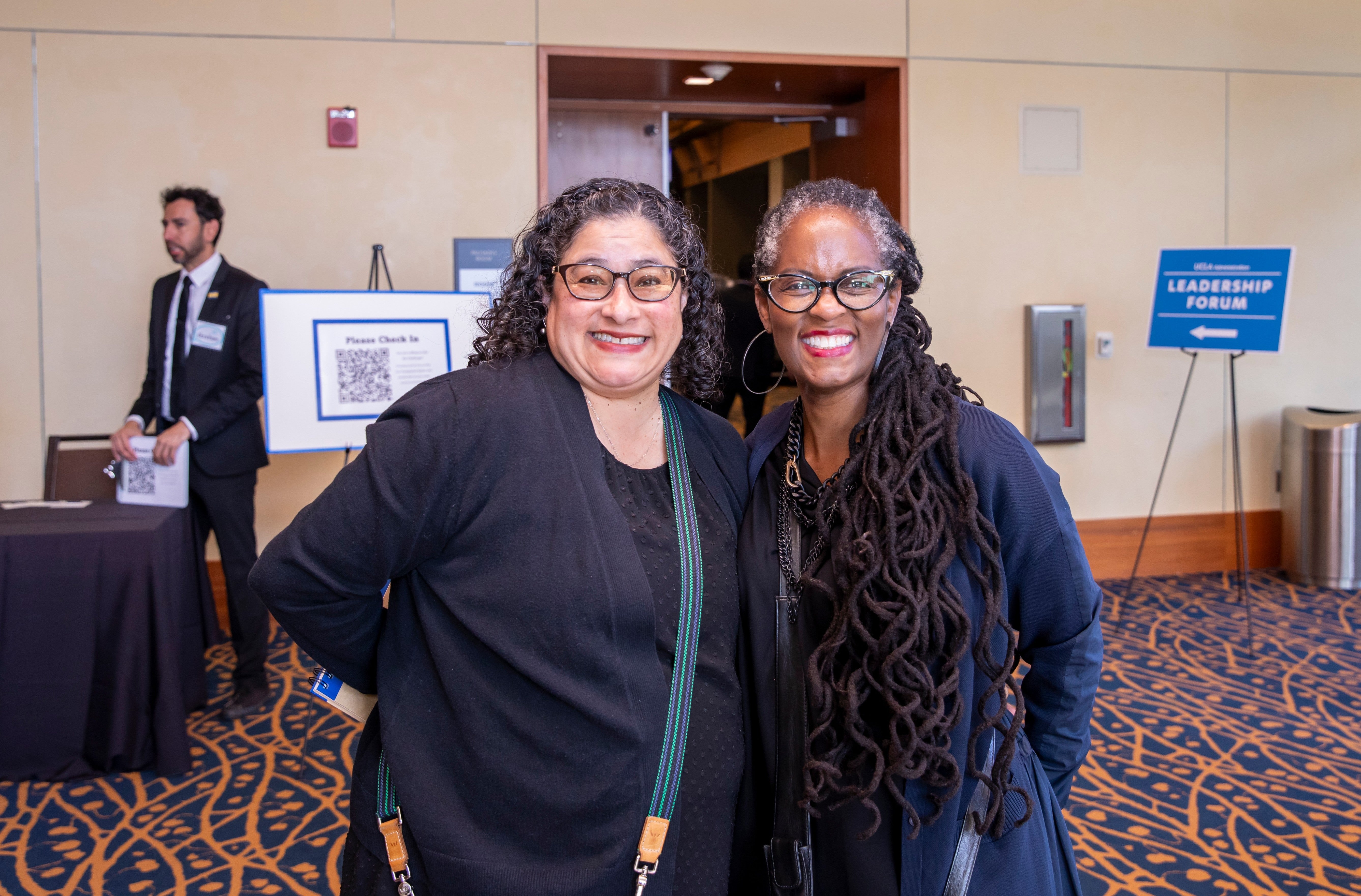 Two female employees smiling at the camera outside the Palisades Ballroom