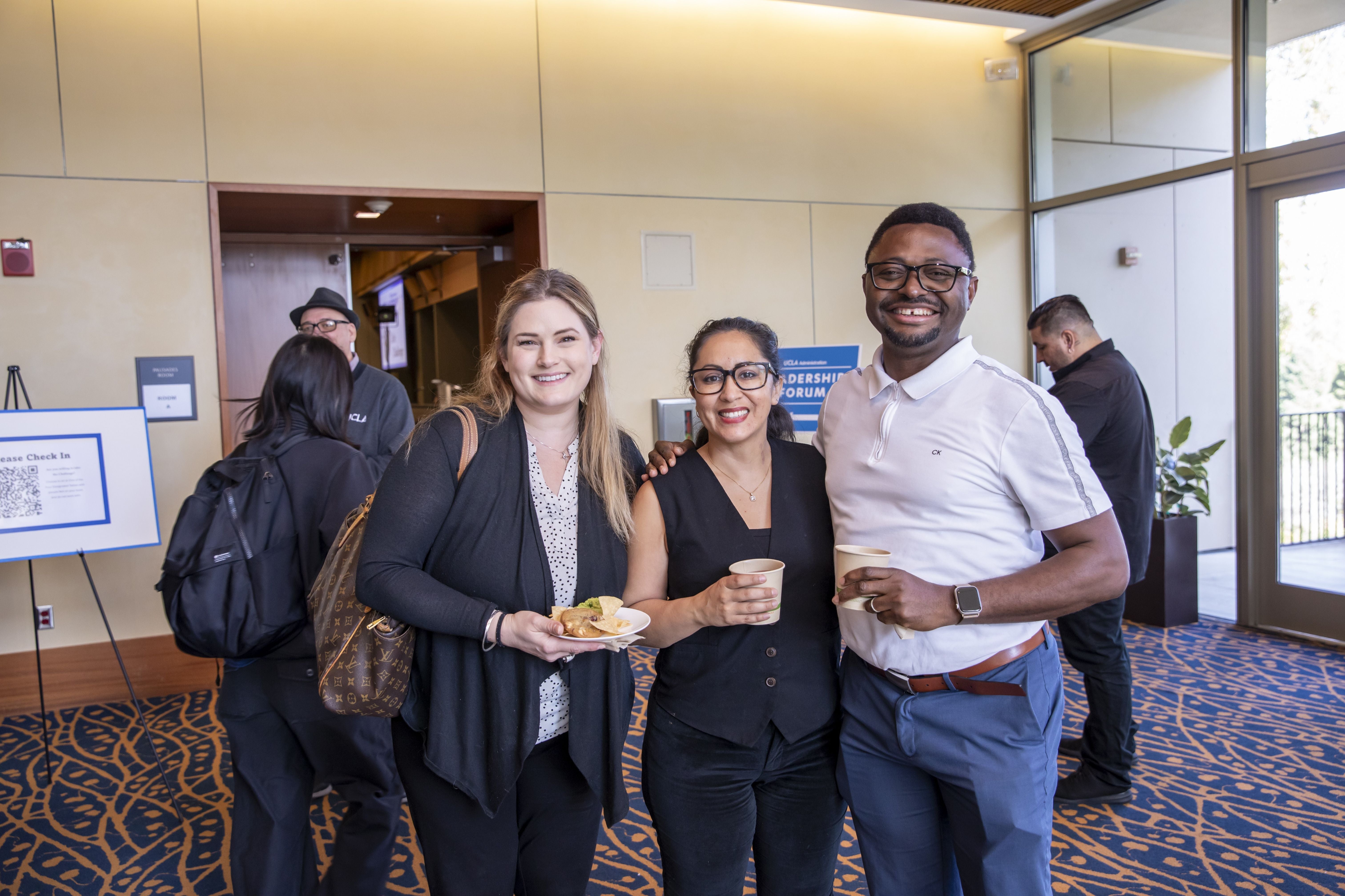 Group of three employees smiling at the camera