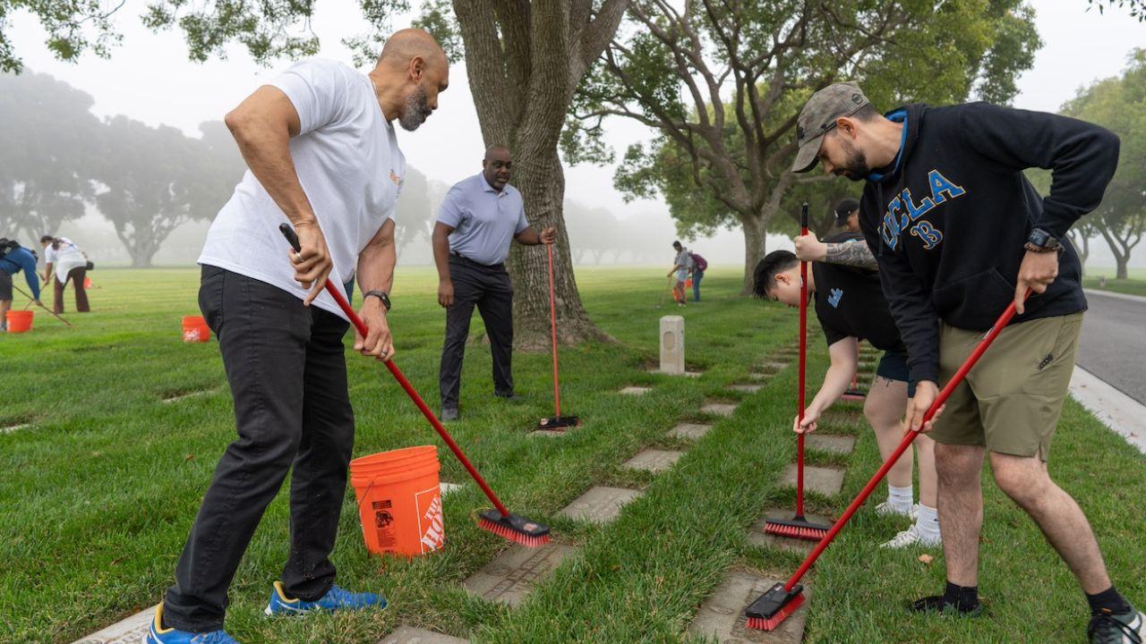 Darnell Hunt and Monroe Gorden Jr. join students in cleaning veterans’ headstones.
