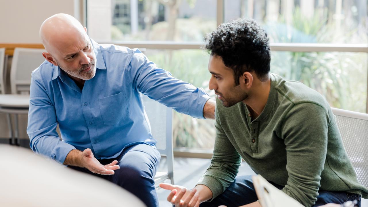 Mature man helps younger man verbalize problems in therapy