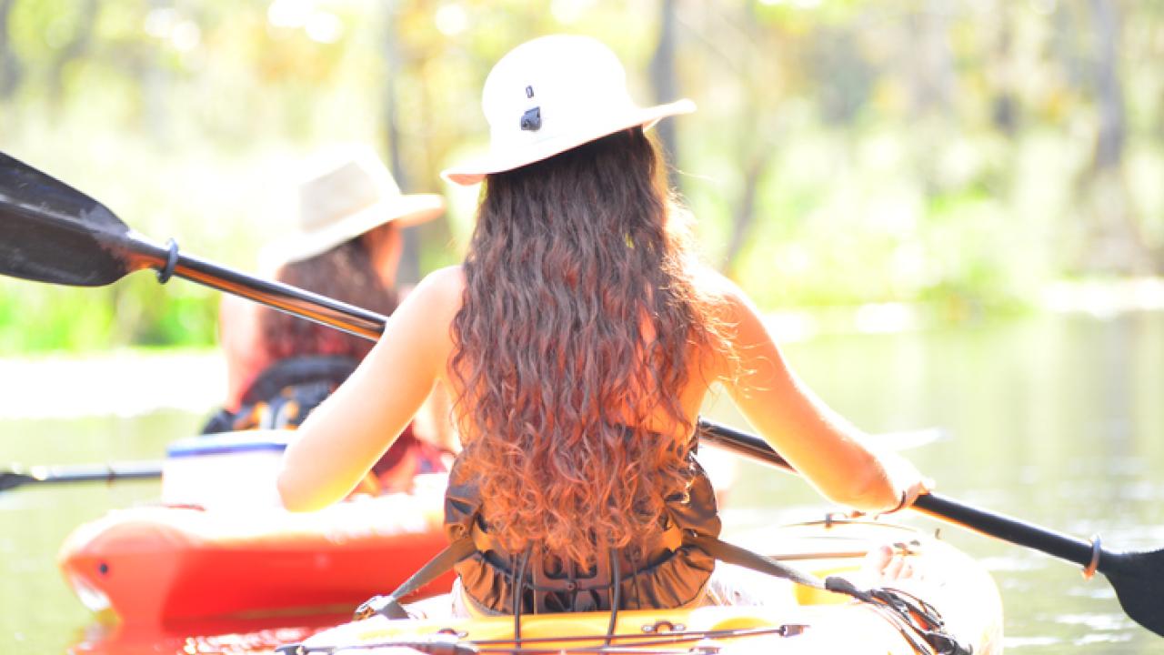 Women in kayaks paddling across the water