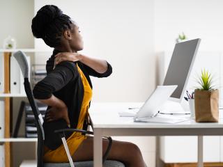 Woman stretching while sitting in office