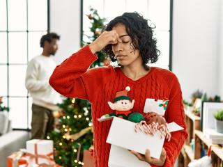 Stressed woman standing next to a Christmas tree