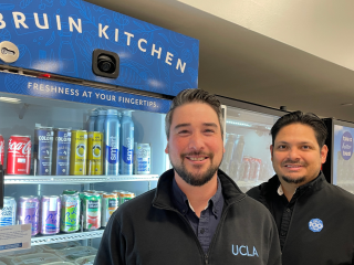 Two men in front of the grab and go at Bruin Kitchen