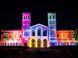 Royce Hall lit with multiple colors